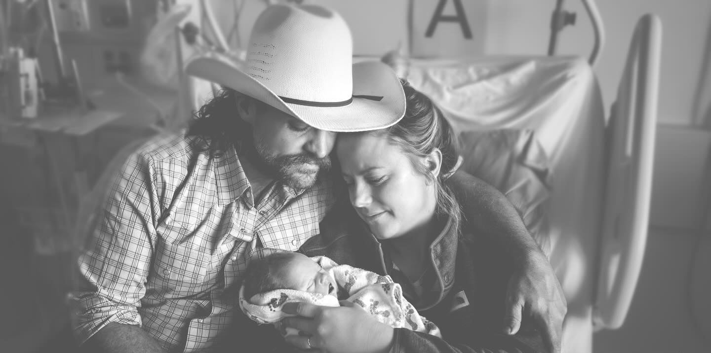 Black and white photo of a couple holding a baby, surrounded by text expressing condolences.
